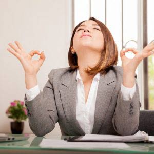 Business woman meditating at desk