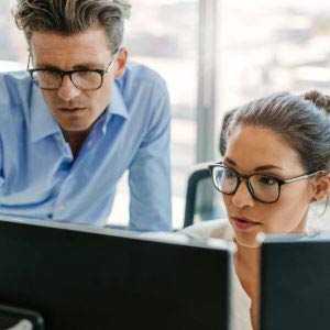 two people looking into computer