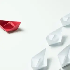 Red paper ship going in different direction