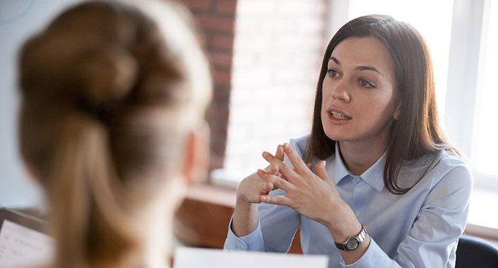 Woman being assertive with another in a meeting