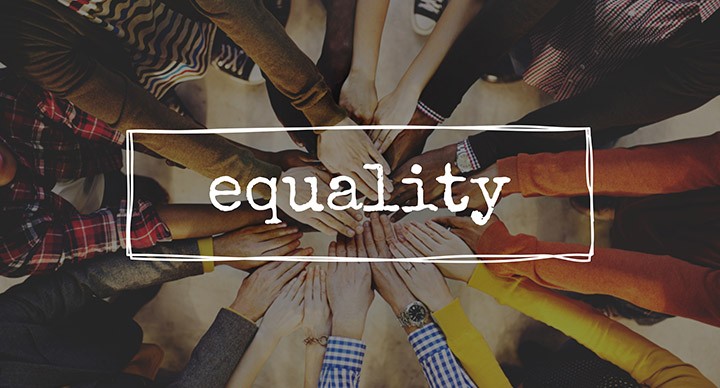 Diverse people symbolising equality by putting their hands together