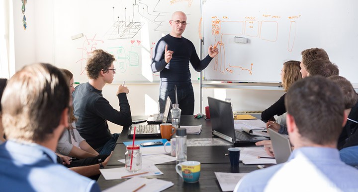 Man presenting in front of people in a meeting