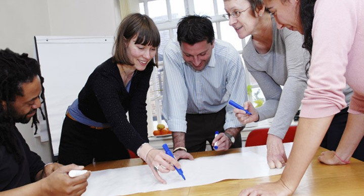 People working on an SDI exercise on a flip chart