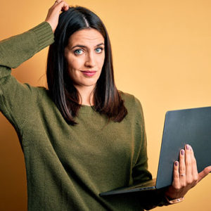 Young brunette woman with blue eyes working using computer lapto